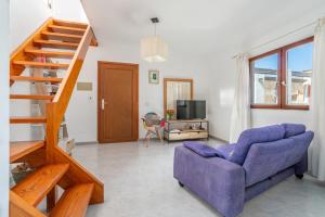 a living room with a purple couch and a staircase at Miramar in Artá
