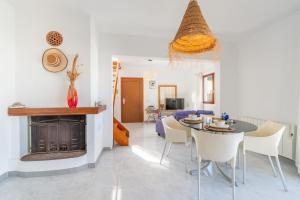 a dining room and living room with a table and chairs at Miramar in Artá
