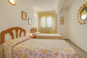 a bedroom with two beds and a mirror on the wall at Apartamento villasol in Arona +14 photos