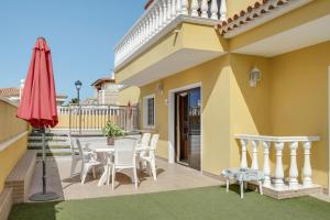 a patio with a table and chairs and an umbrella at Apartamento villasol in Arona