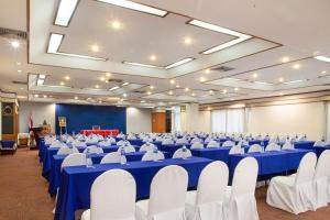 a large banquet hall with blue tables and white chairs at Phrae Nakara Hotel in Phrae +23 photos