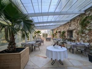 a patio with tables and chairs and a ceiling at PHOENIX maison d'hôtes & SPA in Ginasservis