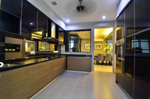 a kitchen with wooden cabinets and a dining room at Plumeria Luxury Service Villa in George Town