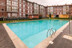 a large swimming pool in front of a building at Piso con piscina in Bádames