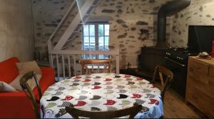 a dining room with a table and a stove at Maison du Pâtre in Urbanya