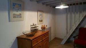a room with a wooden dresser and a staircase at Maison du Pâtre in Urbanya