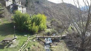 a wooden bridge over a stream with a bridge istg at Maison du Pâtre in Urbanya +3 photos