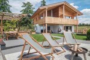 a group of chairs in front of a house at Feichterhof in San Genesio Atesino