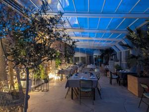 a restaurant with tables and chairs and a blue ceiling at PHOENIX maison d'hôtes & SPA in Ginasservis