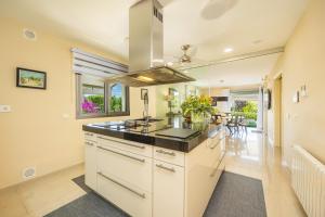 a kitchen with white cabinets and a stove top oven at Villa Bellviure Luxury in Palma in Marratxí 