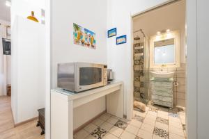 a kitchen with a microwave on a counter with a sink at Alla Marina Monolocale Deluxe in Cagliari +14 photos