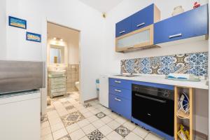 a kitchen with blue cabinets and a black dishwasher at Alla Marina Monolocale Deluxe in Cagliari