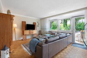 a living room with a large couch and a tv at Haus Petra in Kandern