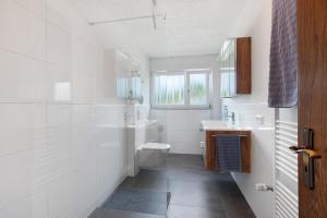 a white bathroom with a toilet and a sink at Haus Petra in Kandern +17 photos