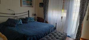 a bedroom with a bed with a blue comforter and a window at Bed and Breakfast sapore da mare in Lido di Ostia
