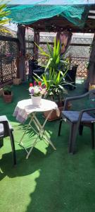 a patio with a table and chairs on green grass at Bed and Breakfast sapore da mare in Lido di Ostia