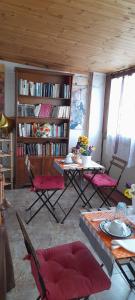 a living room with a table and chairs and book shelves at Bed and Breakfast sapore da mare in Lido di Ostia