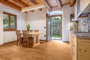 a kitchen and dining room with a wooden table and chairs at Casa al Mulino 2 in Tenno +20 photos