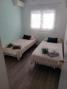 a room with two beds and a window at Bonito bungalow en la playa in Gran Alacant +22 photos