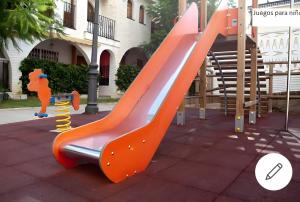 an orange slide at a playground with an image of a cartoon at Bonito bungalow en la playa in Gran Alacant