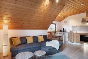 a living room with a couch and a kitchen at Ferienwohnung Steinhart in Lenzkirch