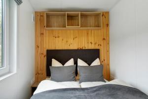 a bedroom with a bed with a wooden wall at Tinyhouse Entspannung und Erholung in Untergriesbach