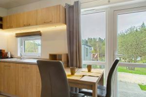 a kitchen with a wooden table and a large window at Tinyhouse Entspannung und Erholung in Untergriesbach