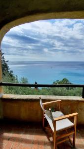 a chair sitting on a porch looking out at the ocean at il Carrubo in Finale Ligure