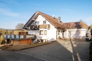 a white house with a roof on a street at Ferienwohnung Steinhart in Lenzkirch