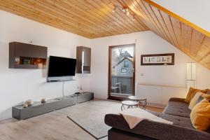 a living room with a couch and a tv at Ferienwohnung Steinhart in Lenzkirch