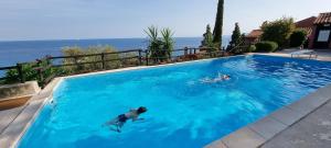 two people swimming in a large blue swimming pool at il Carrubo in Finale Ligure