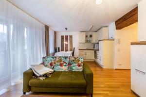 a living room with a green couch and a kitchen at Alte Schule in Münsingen