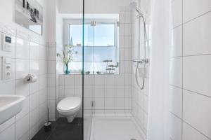 a white bathroom with a toilet and a window at Ferienwohnung Bachem mit Balkon in Bad Neuenahr-Ahrweiler +15 photos