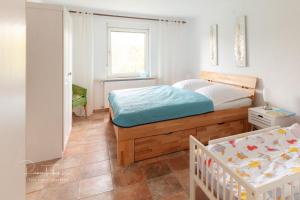 a bedroom with a bed and a crib in it at Ferienhaus Specht in Schotten