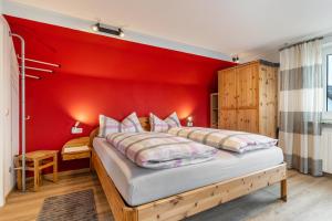 a bedroom with a red wall and a bed at Haus Ursula in Ettenheim