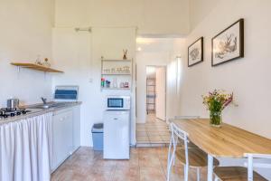 a kitchen with a wooden table and a dining room at Mas des Cypres - Mazet 9 in Saintes-Maries-de-la-Mer +17 photos