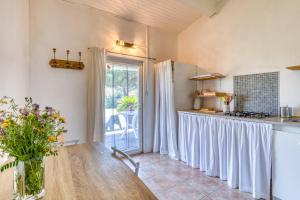 a kitchen with a table with a vase of flowers at Mas des Cypres - Mazet 9 in Saintes-Maries-de-la-Mer