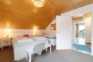 a bedroom with two beds and a wooden ceiling at Casa Limone in Ammerbuch