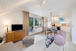 a living room with a couch and a tv and a kitchen at Casa Limone in Ammerbuch