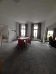 a living room with a table and chairs and windows at Meeresleuchten 2 in Emden