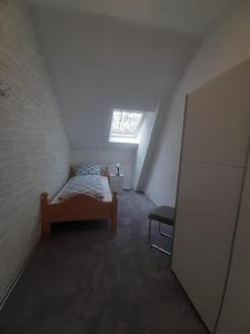 a attic room with a bed and a window at Meeresleuchten 2 in Emden