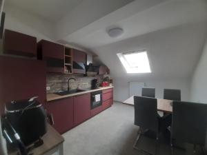 a kitchen with purple cabinets and a table with chairs at Meeresleuchten 2 in Emden