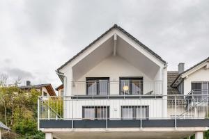 a white house with a large balcony at Ferienwohnung Vogesenpanorama in Bad Bellingen