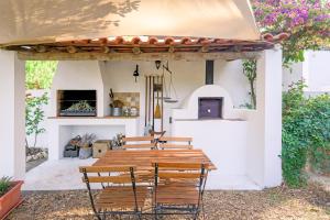 a wooden table and chairs on a patio at Alquimia, Alchemy, Alchimie in São Luis