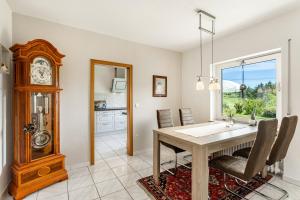 a dining room with a table and a grandfather clock at Ferienwohnung Auszeit Sauerland in Meinerzhagen