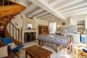 a living room with a table and a kitchen at Isatis in Mortagne-sur-Gironde