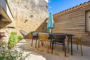 a table with chairs and an umbrella on a patio at Isatis in Mortagne-sur-Gironde +15 photos