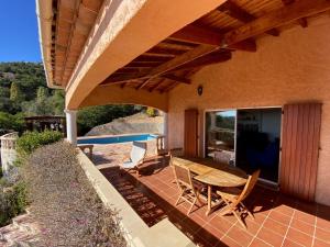 an outdoor patio with a wooden table and chairs at Villa Lucio in La Londe-les-Maures