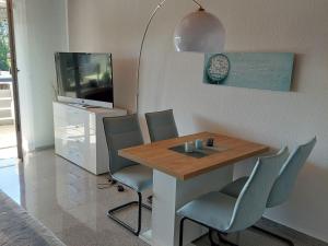 a dining room with a table and chairs and a tv at Ferienwohnung Sander mit Innenpool in Möhnesee