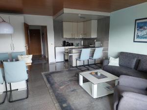 a living room with a couch and a table at Ferienwohnung Sander mit Innenpool in Möhnesee